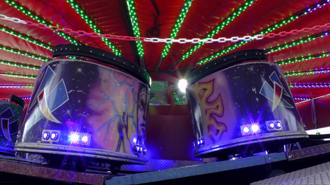 Fairground ride lit up with neon lights at night